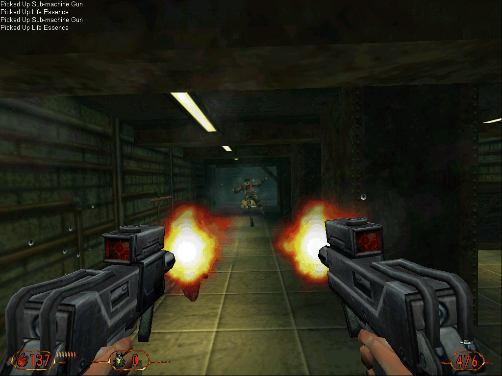 Caleb disparando dos subfusiles a la vez contra un enemigo en un pasillo industrial de Blood II