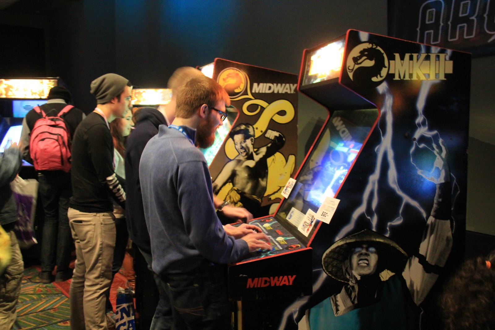 Gabinete original de Mortal Kombat II en un evento, con gente esperando su turno